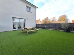 Les Dunes - Calme et Sérénité à 5 min de la Plage en voiture في Biville-sur-Mer: طاولة نزهة في ساحة بجوار منزل