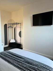 a bedroom with a bed with a flat screen tv on the wall at 180b Wells Road in Bristol