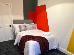 a bedroom with a large bed with an orange headboard at 180b Wells Road in Bristol