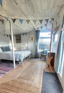 a bedroom with a bed in a room with a window at Treguth Glamping Unique Experience - Themed Huts in Saint Day