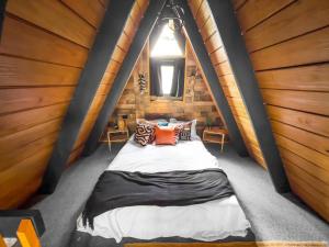 a bedroom with a bed in a wooden cabin at Africa787 A Frame Wood House With Pool in Lajas in Lajas