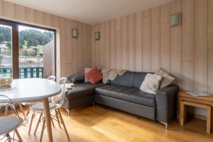 a living room with a couch and a table at Apartment Grizzly - 2 bedrooms - Ski in/out- Les Gets in Les Gets