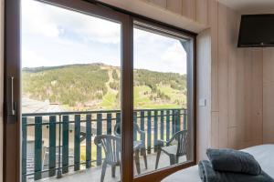 a room with a balcony with a sliding glass door at Apartment Grizzly - 2 bedrooms - Ski in/out- Les Gets in Les Gets