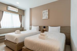 a hotel room with two beds and a window at Finn Hotel in Ban Fang Daeng +125 photos