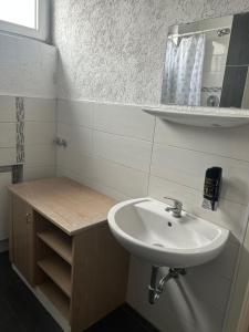 un bagno con lavandino e specchio di Hotel RI a Esslingen Altre 10 foto