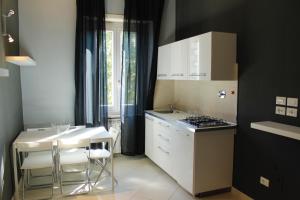 トリノにあるSan Donato Apartmentsのキッチン(コンロ、テーブル、椅子付)
