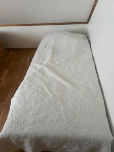 a bed with a white comforter in a room at Gamle bygdevei 198b in Oslo