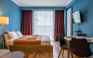 a hotel room with a bed and a desk with a computer at New Gudauri GN Apartments in Atrium in Gudauri
