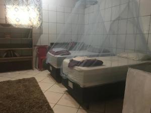 two beds in a room with a glass wall at Camping-Casa Saco do Ceu in Saco do Ceu
