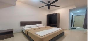 HP Usima Forest Resort Melaka في آير كيروه: غرفة نوم بها سرير ومروحة سقف +10 صور