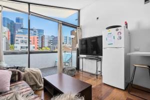 a living room with a refrigerator and a large window at Melbourne suites - Zen Oasis or skyline views in Melbourne