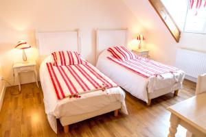 two beds in a room with two tables and two lamps at Domaine de la Croix Tibi in Guilly