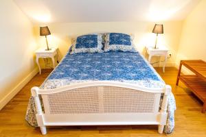 a white bed in a room with two night stands at Domaine de la Croix Tibi in Guilly