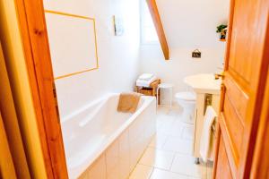 a bathroom with a tub and a toilet and a sink at Domaine de la Croix Tibi in Guilly