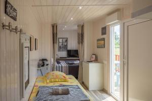 a small bedroom with a bed and a kitchen at Chambre d'hôtes du Cerisier in Noyers