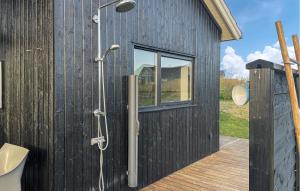 Un edificio negro con ducha y ventana. en Awesome Home In Føllenslev With Wifi, en Havnsø