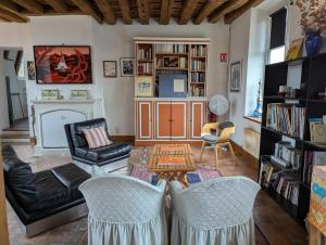 a living room with a table and chairs and a fireplace at Domaine de Bel Ebat in Paucourt