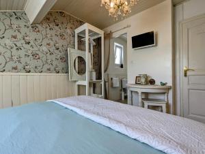 a bedroom with a bed and a table and a chandelier at Chambre Verte, La Bastide in Rosières