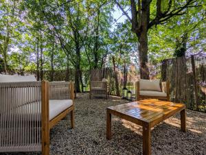 un patio con 2 sillas y una mesa de centro en Chambre Verte, La Bastide, en Rosières