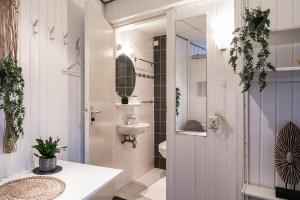 Budget Private Room Near Zoutelande Beach في زوتلاند: حمام مع حوض ومرحاض ومرآة