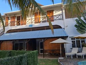 a building with a blue awning and an umbrella at A few steps from the beach in Pereybere