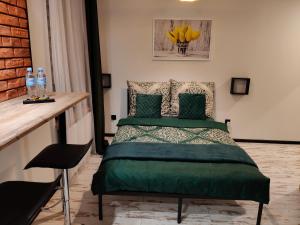 a bedroom with a bed with a green comforter at Apartamenty Królówka in Bydgoszcz