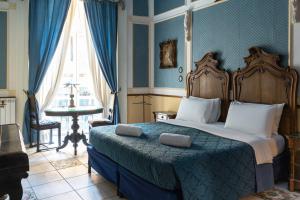 a bedroom with a bed and a table and a window at Carafa di Maddaloni Residenza di Charme in Naples