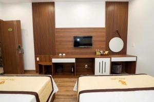 a hotel room with two beds and a television at Mai Linh Hotel in Ha Long