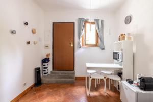 a kitchen with a table and chairs and a door at La Casetta di Via Sannio in Rome