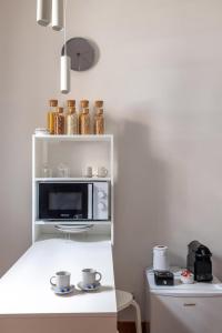 a kitchen with a white counter with a microwave at La Casetta di Via Sannio in Rome +7 photos