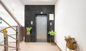 a elevator in a building with potted plants at Itsy Hotels Svaruchi Inn in New Delhi