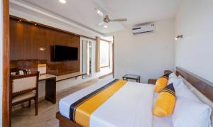 a bedroom with a bed and a desk and a television at Itsy Hotels Svaruchi Inn in New Delhi +26 photos
