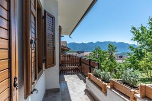 un balcone con piante in vaso e una finestra aperta di Dimora al Peller Tuenno OSPITAR a Tuenno