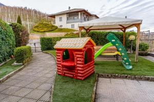 una casa dei giocattoli con uno scivolo e un parco giochi di Dimora al Peller Tuenno OSPITAR a Tuenno