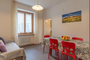 una sala da pranzo con un tavolo e sedie rosse di Dimora al Peller Tuenno OSPITAR a Tuenno