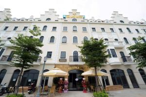 a large white building with umbrellas in front of it at Mai Linh Hotel in Ha Long