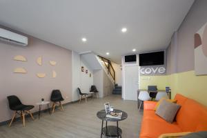 a living room with an orange couch and chairs at Cove Anasera in Jombang
