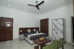 a bedroom with a bed and a ceiling fan at Taposthalam Sacred Retreat Hotel in Rishikesh in Rishīkesh