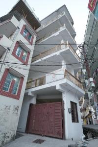a white house with a wooden door and stairs at Taposthalam Sacred Retreat Hotel in Rishikesh in Rishīkesh +8 photos