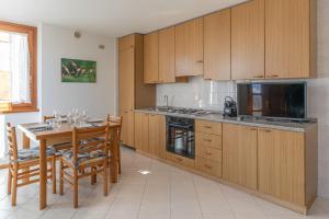 a kitchen with wooden cabinets and a table with chairs at Surgiva del Sòm in Folgaria +20 photos