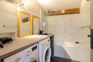 a washing machine in a bathroom with a shower at Six-Deniers in Les Gets +25 photos