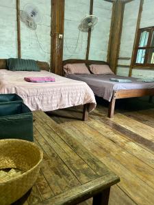 een kamer met twee bedden en een tafel erin bij Bruno bungalow in Sihanoukville