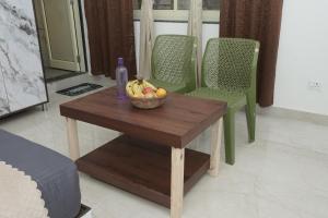 a table with a bowl of fruit and a bottle on it at Taposthalam Sacred Retreat Hotel in Rishikesh in Rishīkesh