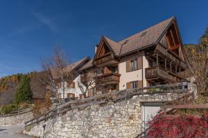 a large house on a stone wall at Surgiva del Sòm in Folgaria
