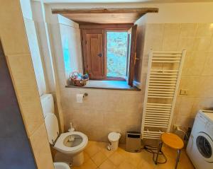 un piccolo bagno con servizi igienici e finestra di Casa Rosa a Vetriano