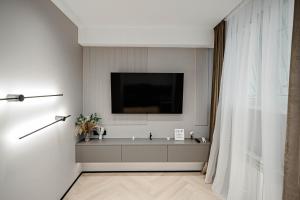 基希讷乌Urban Elegance的墙上配有电视的浴室