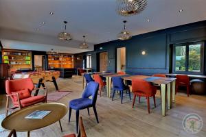 a restaurant with tables and chairs in a room at Manoir de la droulinais in Bruz