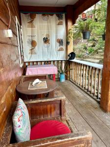 een veranda met een tafel en stoelen en een tafel en een raam bij Bruno bungalow in Sihanoukville +3 foto's