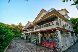 a building with a fence in front of it at Hotel Eyokar Goa in Candolim