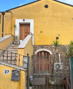 ein gelbes Gebäude mit einer Treppe und einer Tür in der Unterkunft La Finestra sul Teatro Romano in Benevento